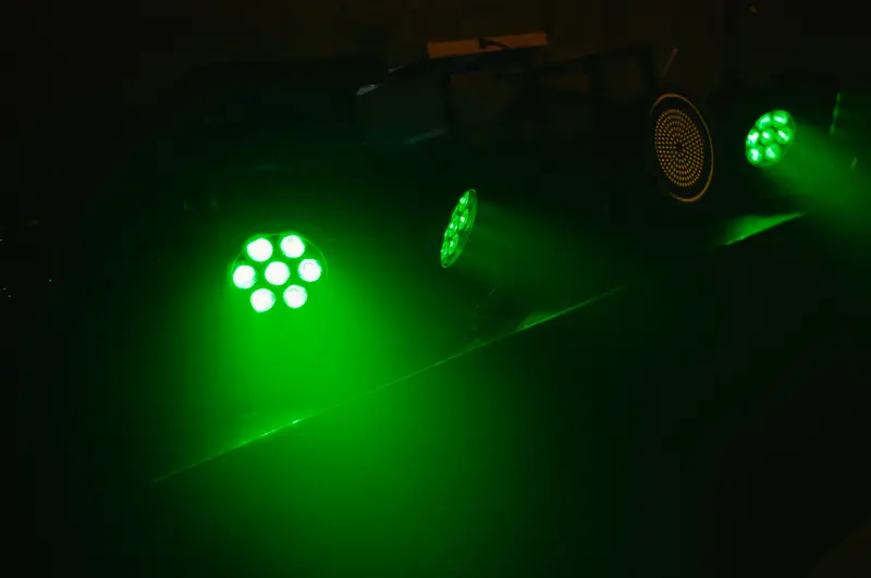 Die Scheinwerfer am DJ-Pult in Gr&uuml;n, die Lichtkegel zeichnen sich im Nebel ab